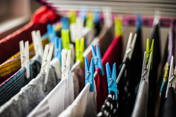 abiti e vestiti appesi ad asciugare con le mollette colorate