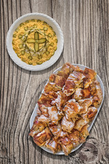 Plateful of Spit Roasted Pork And Olivier Salad On Old Wooden Picnic Table