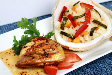 Coconut rice with fried chicken and vegetables on white plate