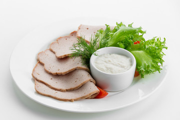 Sliced meat plateau ham with sauces and salad on white plate