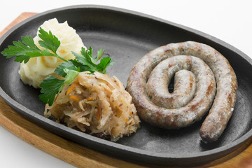 From turkey roasted with paprika sausages in black pan on wooden