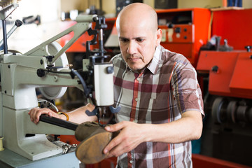 Shoemaker working in shoe atelier.