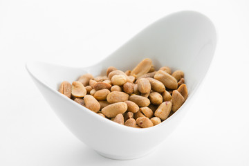 Fried peanuts in white bowl on white background