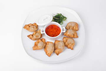 Fried dumplings with chili fish sauce on white plate background