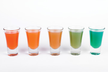 Glasses of cocktail in different color on white background