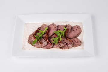 Roast beef with tuna sauce and herbs on white background