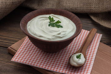 delicious sour cream in a wooden bowl on the table