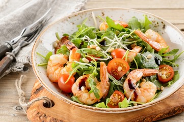 Rocket salad with prawns shrimps, sprouts and green cabbage on w