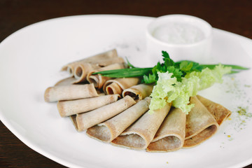 Sliced pork meat with lettuce on white plate in restaurant