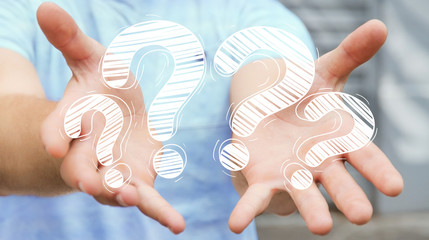 Businessman holding hand drawn question marks in his hand