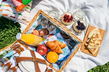 Foto auf Acrylglas Picknick Picknickkorb mit Früchten, Orangensaft, Croissants, Quesadilla und ohne Backen Blaubeer- und Erdbeermarmelade-Käsekuchen