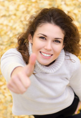 Portrait of a smiling woman, showing thumb up