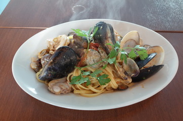 Pasta noodle of clams and mussels with herbs on white plate