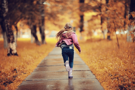 Girl 6-7 runs in the autumn park