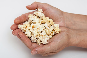 Female hand with popcorn on a white background