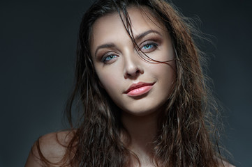 Naklejka premium Sexy beauty. Close-up studio portrait of young fashion model with beautiful blue eyes looking at camera.