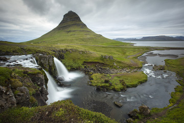  Waterfall with triangle mountain and gray sky in Iceland