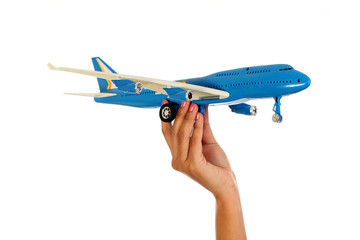 Woman hand holding toy plane against white background
