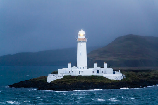 Lighted Lismore lighthouse in Scotland at dusk