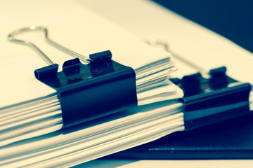Piles of documents with black clip