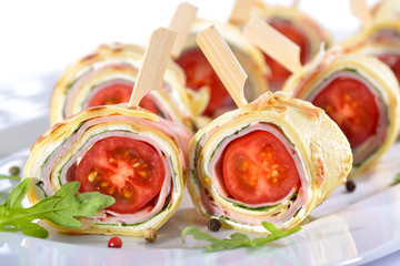Leckere Crepes-Röllchen mit Schinken, Käse, Rucola und Tomate -  Delicious finger food: Rolls of...