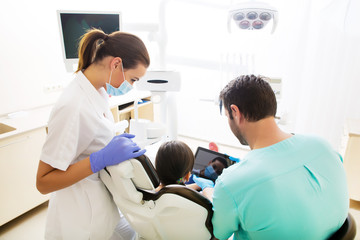 Obraz na płótnie Canvas Dentist with a little girl and a Tablet PC.