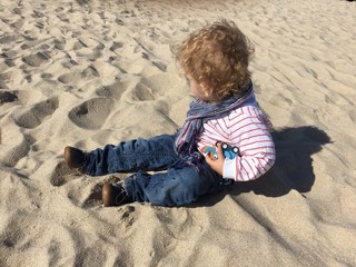 Kleinkind Baby sitzt im Sand