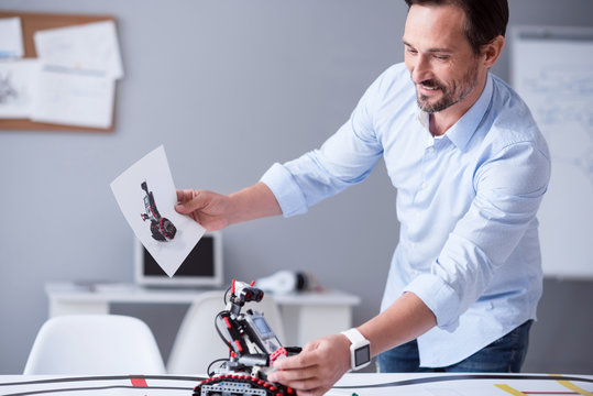 Happy Scientist Holding A Prototype Of His Invention