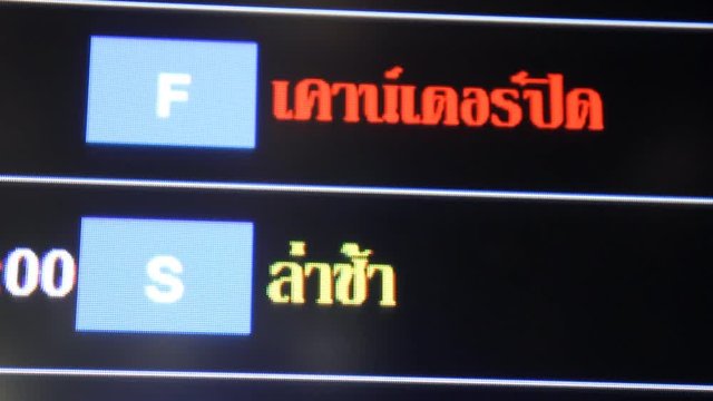 Flight delayed on information board in airport terminal.