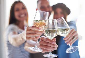 Toasting wine glasses with people behind them