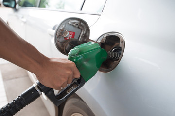 Men hold Fuel nozzle to add fuel in car
