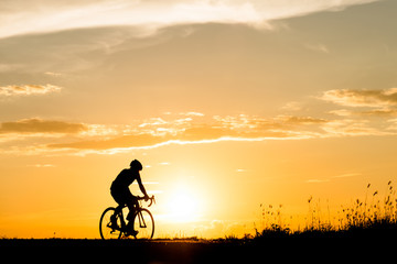 Obraz premium Silhouette of cyclist motion on sunset background