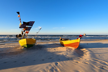 Traditional fishing boats on sandy beach in Jantar village at sunset time. Baltic sea, Poland.