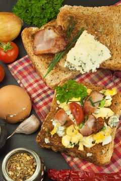 Toast with scrambled eggs. Quick and nutritious breakfast. Eggs with vegetables and bacon. Dietary supplements for athletes. Protein meal.
