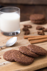 Biscuits with glass of milk on natural wooden table.