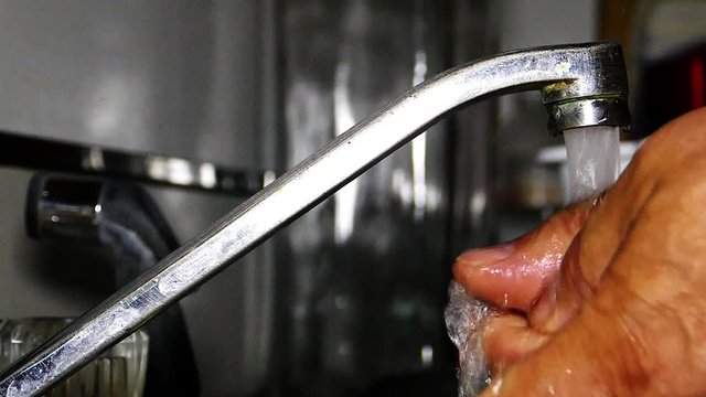Wahing hand in kitchen slow motion