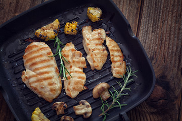 Grilled chicken breast with mushroom and rosemary  on a wooden board or grill pan 