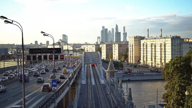 The skyscrapers, the Third Ring Road and the ES2G Lastochka (Swallow) trains on the Moscow Central Circle line at sunset. Time-lapse. UHD - 4K. September 14, 2016. Moscow. Russia