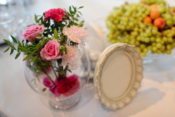 Beautiful wedding restaurant for marriage. White decor for bride and groom. Colorful decoration for celebration. Beauty bridal interior. Bouquet, food and flowers in hall