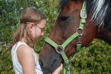 YOUNG GIRL HUGGING HER HORSE