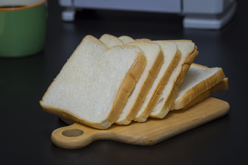 Toster with sliToaster with slide bread on black desk - Selective focus