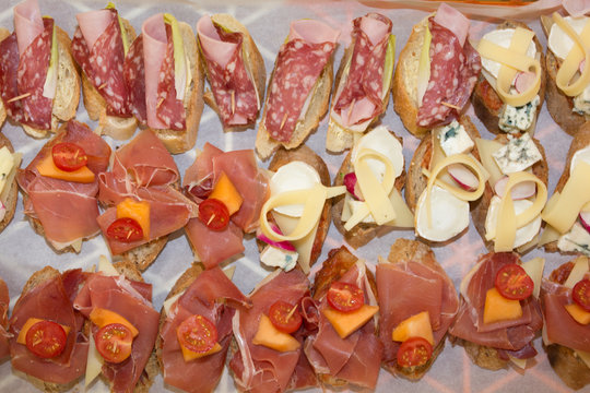 Selection of Spanish tapas served on a sliced baguette.