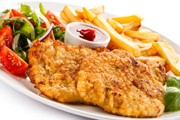Fried pork chop, French fries and vegetables 