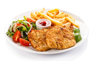 Fried pork chop, French fries and vegetables 