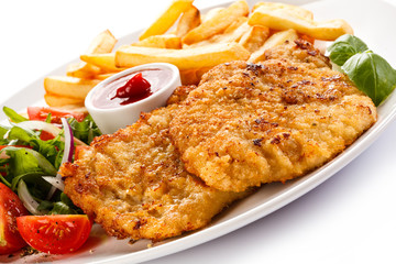 Fried pork chop, French fries and vegetables 