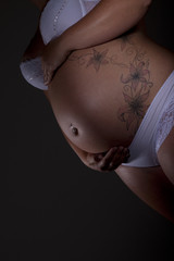 Schwangere Frau mit Tattoo auf Babybauch Porträt