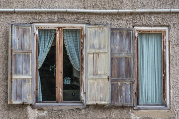 Renovierungsbedürftige Fenster mit verwitterten Holzläden