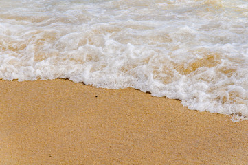 Foam wave on sea close with beach background