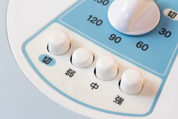 Power switching device on a white and blue Japanese electric fan