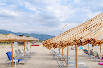 Reed umbrellas beach with blurred beach close